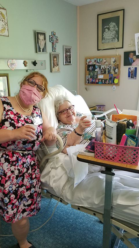 Ann Turano, a resident of Wayne Woodlands Manor, enjoys “Popcorn & Non-alcohol-Margarita Day” at the facility with activities aide Debbie Bishop.